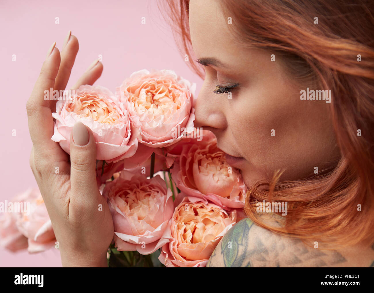 Cute woman is sniffing a bouquet of pink Buttercup Asian Stock Photo
