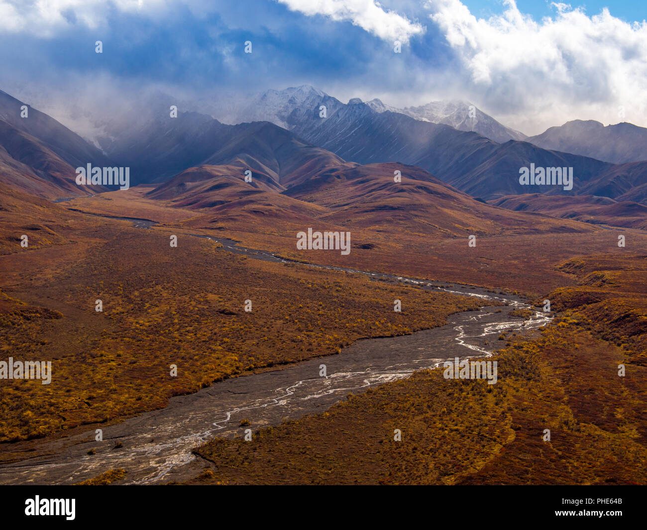 Braided River Flowing From Mountain Range Shrouded in Clouds, Denali National Park, Alaska Stock Photo