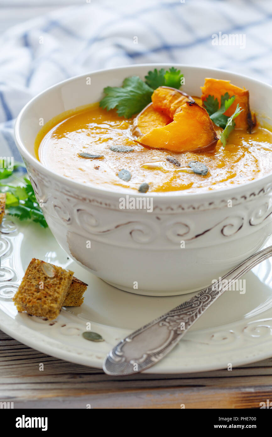 Pumpkin soup with chunks of baked pumpkin and spices. Stock Photo