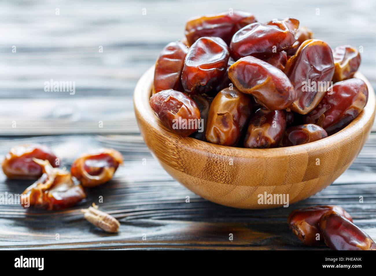Dried date fruit in a wooden bowl. Stock Photo