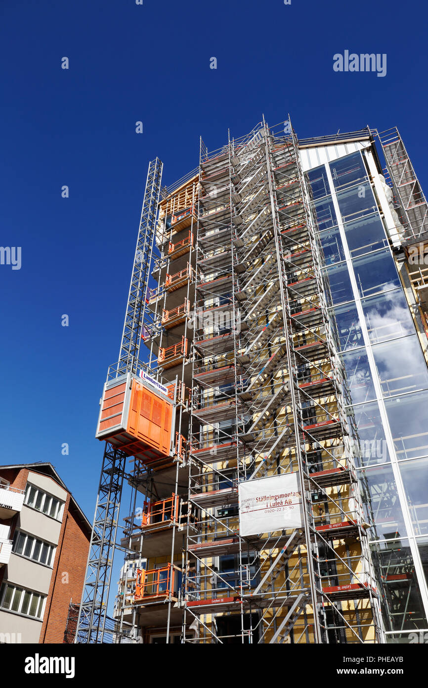 Lulea, Sweden - June 20, 2018: Low angel view of a construction of high rising building at the Kungsgatan street with scaffolding and and temporary bu Stock Photo