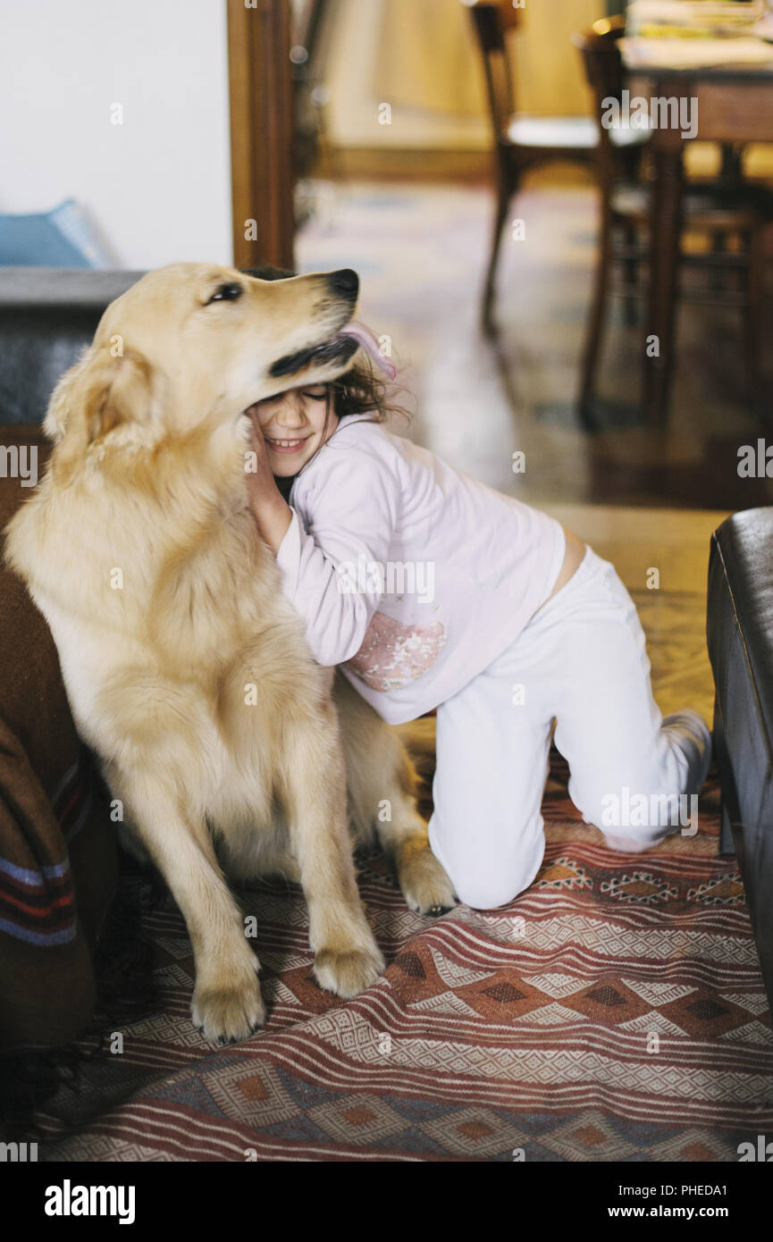 little girl at home with her golden retriever dog Stock Photo - Alamy