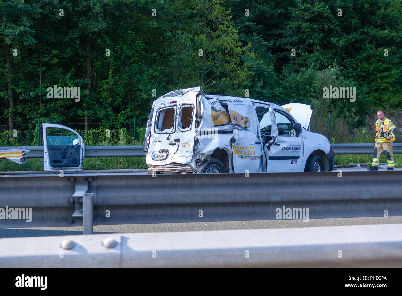 Slovenian Post Van damaged in car accident on Styrian Highway A1 near Blagovica, Fireman walking toward the vehicle. The A1 is one of busiest highways in Slovenia. Stock Photo