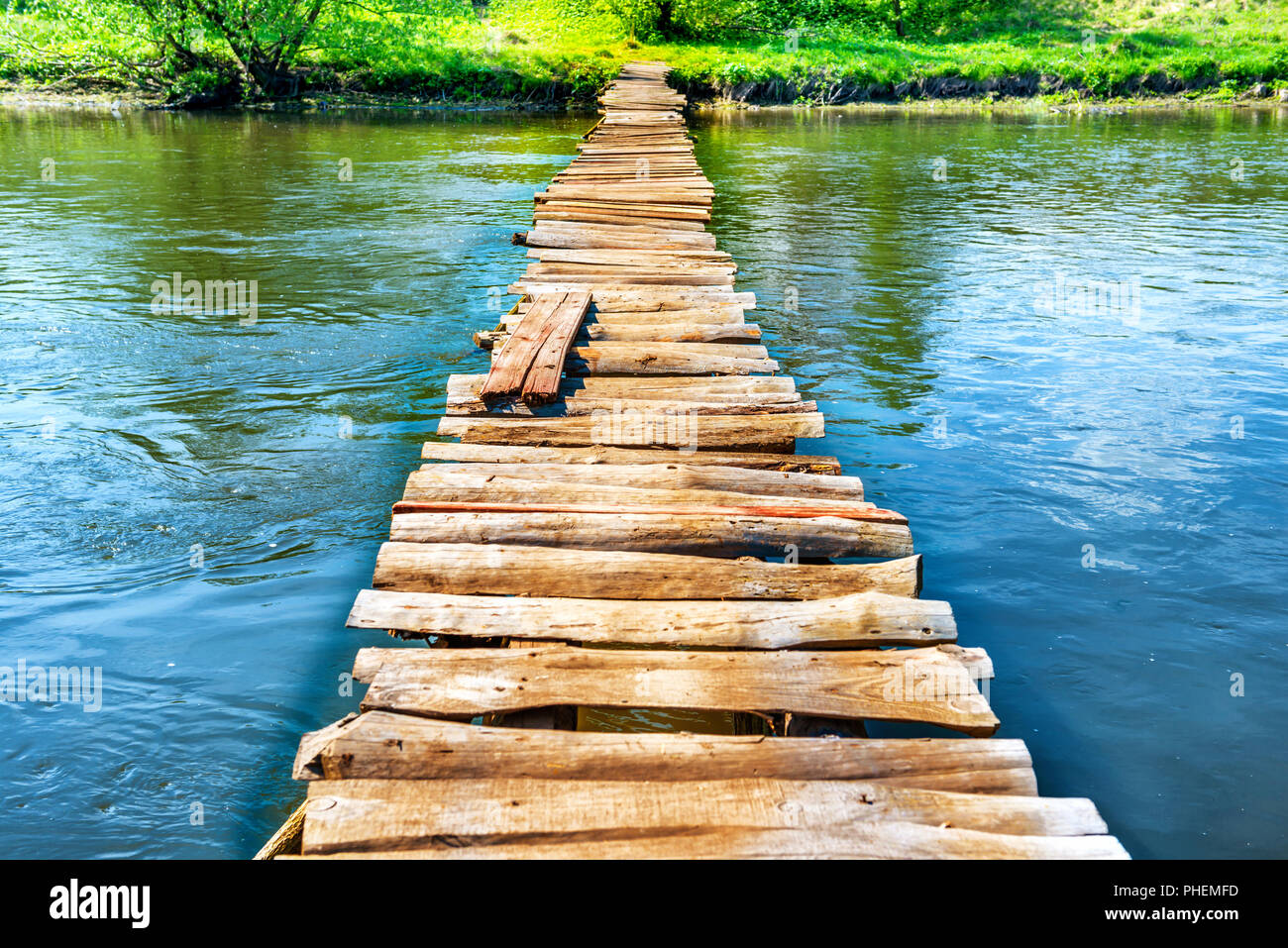 Old wooden bridge through the river Stock Photo