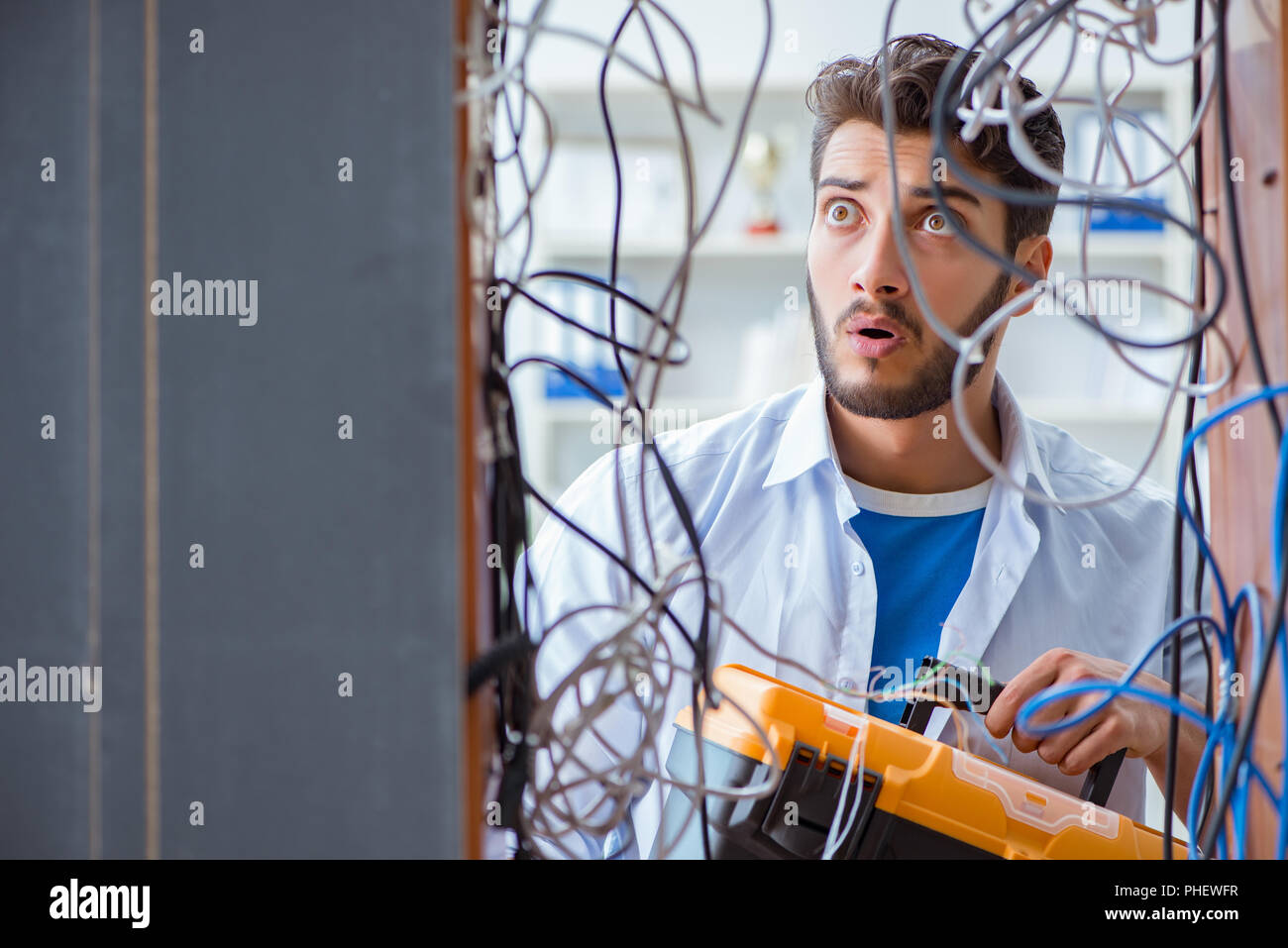 Electrician trying to untangle wires in repair concept Stock Photo Alamy