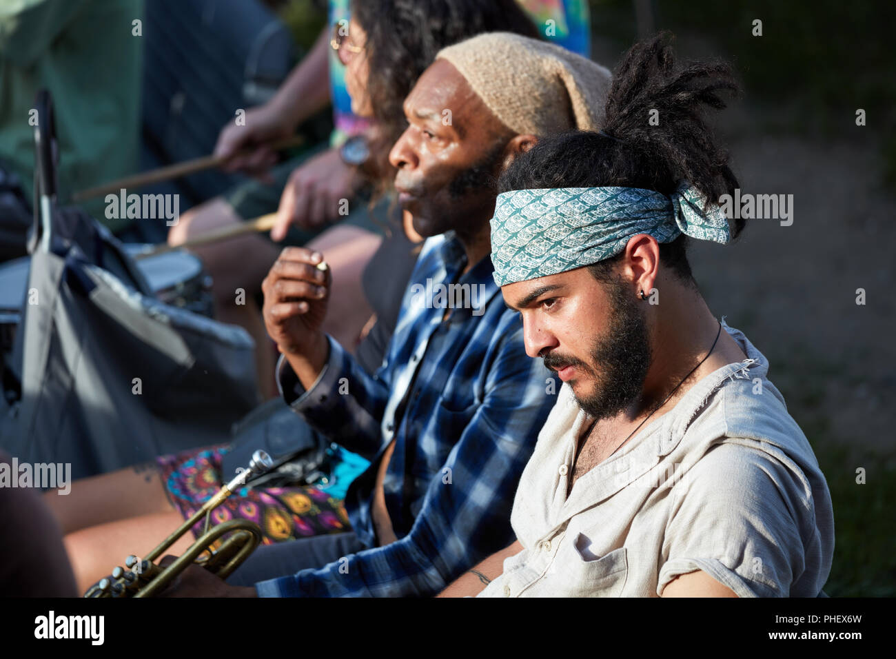 Montreal, Canada - June, 2018. Portrait of a young handsome hispanic latino and an African American male trumpet player sitting next to each other. Mu Stock Photo