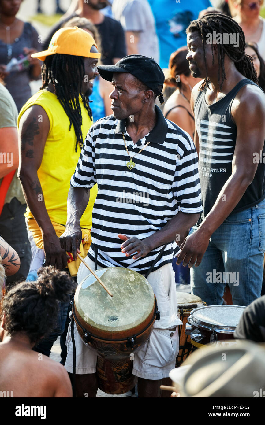 African American male percussionist playing his djembe drum bongo at
