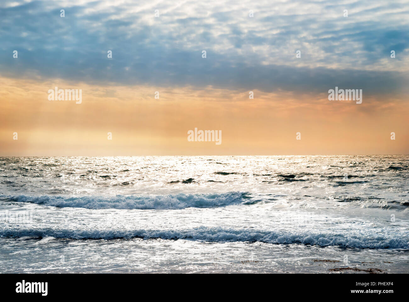 Sunset on the blue sea with waves Stock Photo - Alamy