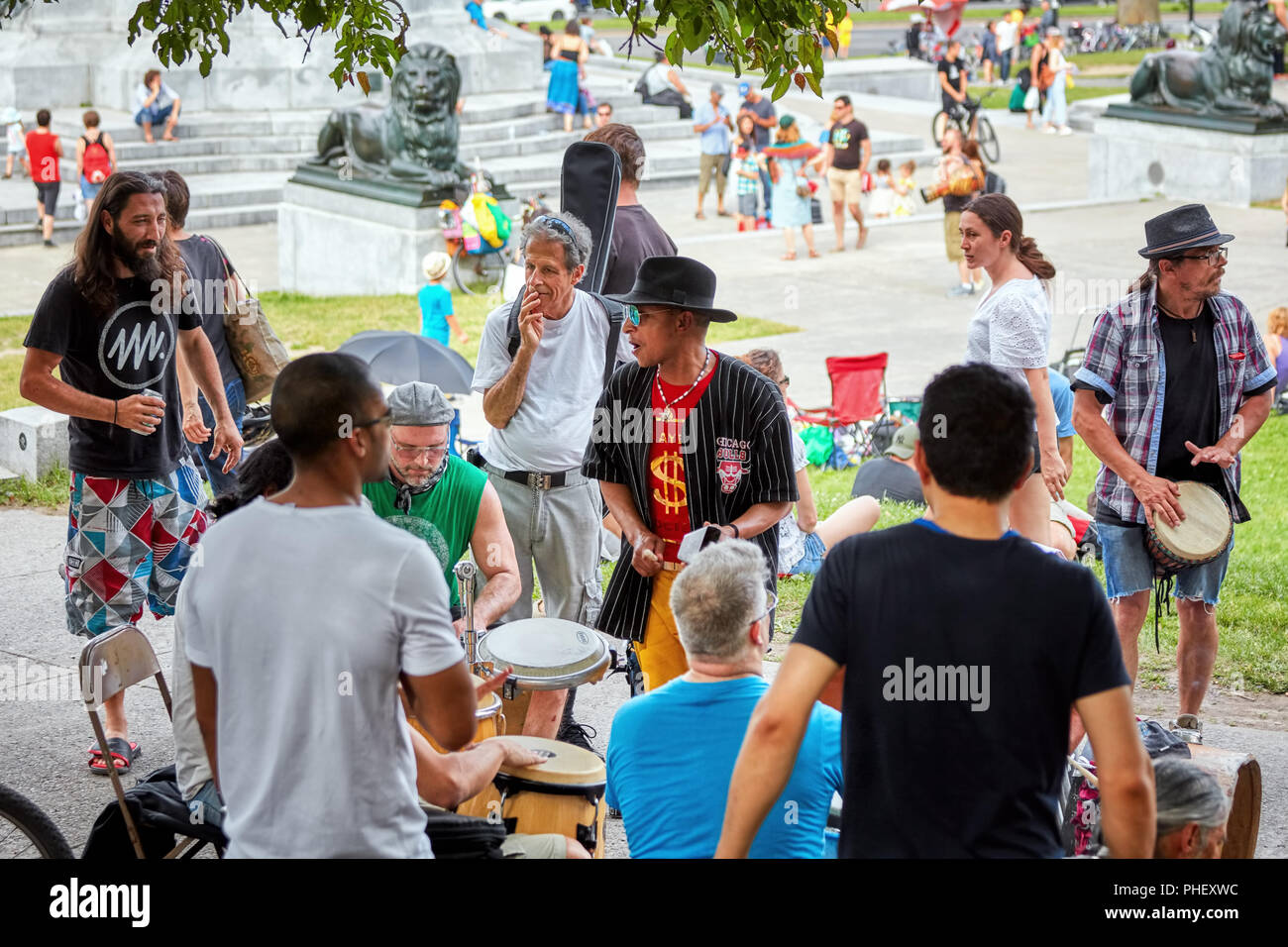 Group of African American and Caucasian drummers and percussionists playing rhythm at Tam Tams festival in Mount Royal Park, Montreal, Quebec, Canada Stock Photo