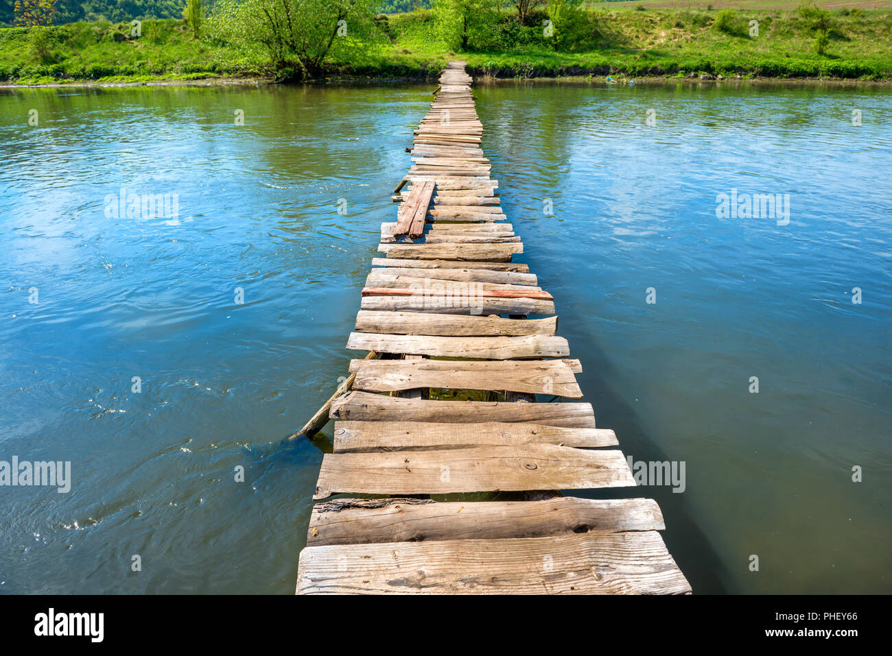 Old wooden bridge through the river Stock Photo