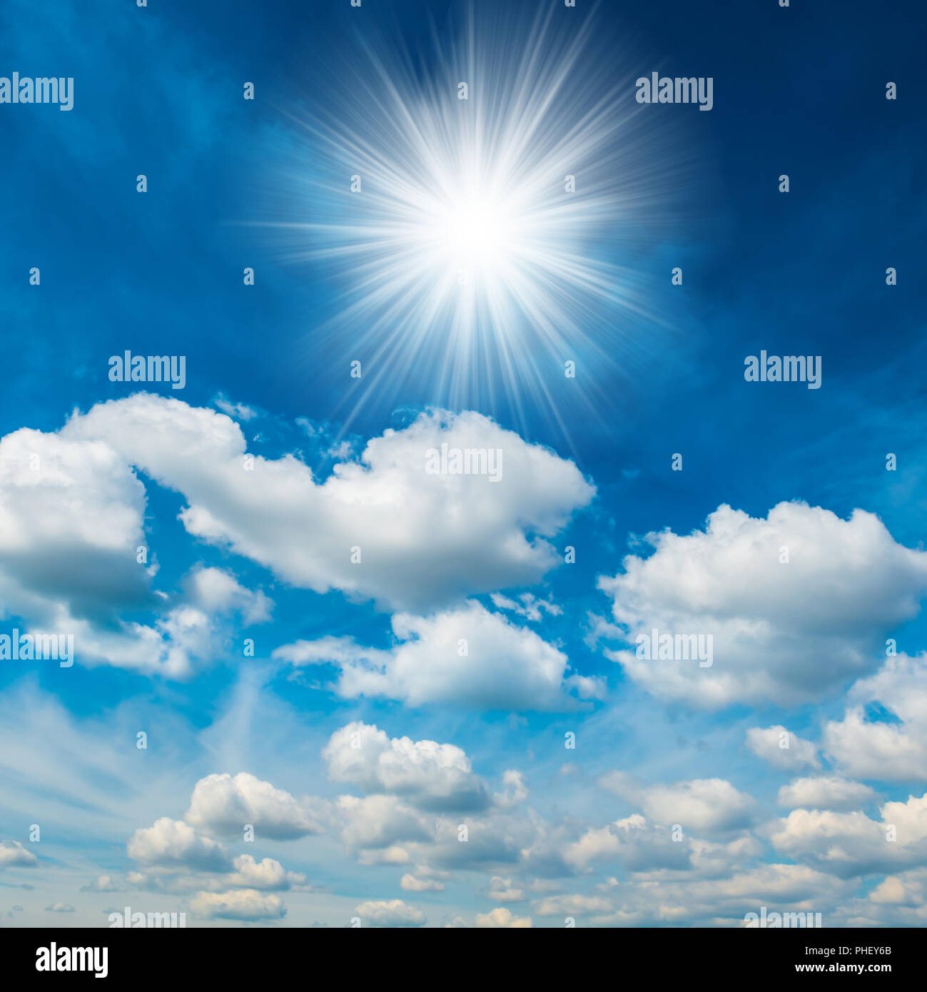 Bright shining sun with white clouds Stock Photo