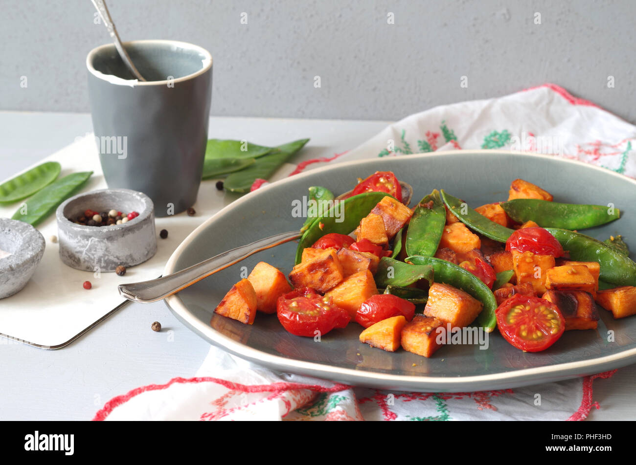 roasted kumara with sugar snaps and tomatos Stock Photo Alamy