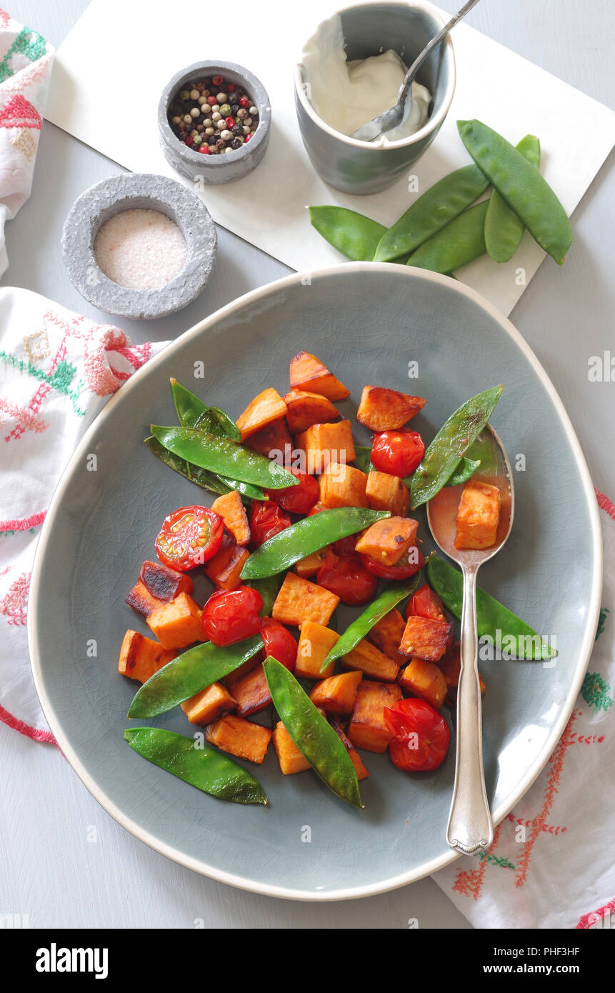 roasted kumara with sugar snaps and tomatos Stock Photo Alamy