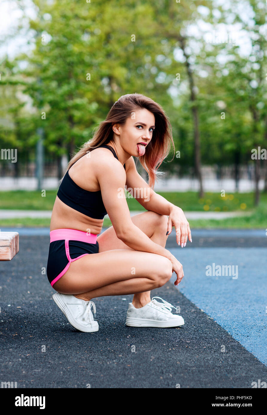 Sporty woman with perfect athletic body posing near horizontal bars Stock Photo