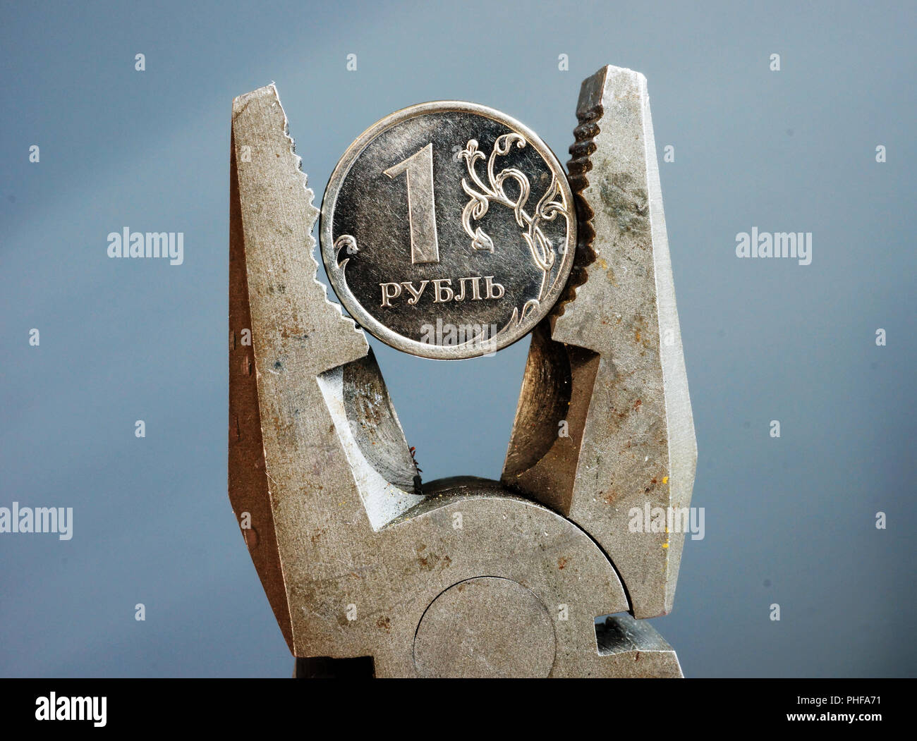 Pliers squeezed the Russian ruble. Economic sanction and stagnation. Stock Photo