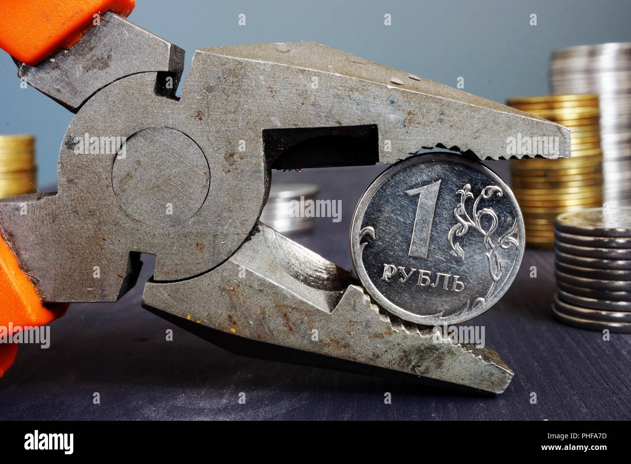 Sanctions for Russia and inflation. Pliers holding russian ruble. Stock Photo