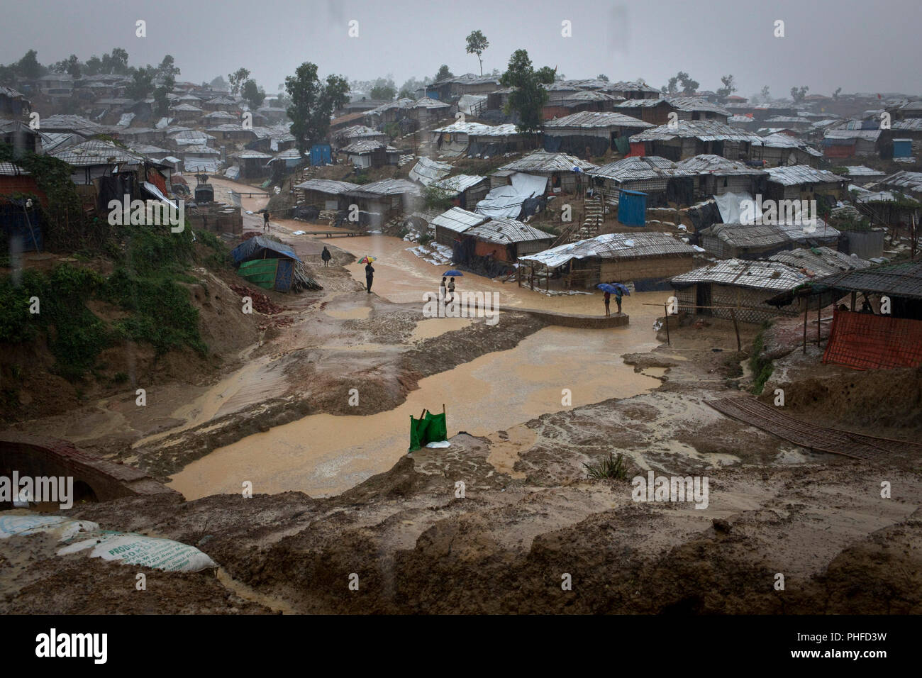 Rohingya refugees shield from the rain in Balukhali, Camp 10, part of the mega refugee camp sheltering over 800,000 Rohingya refugees, Cox's Bazar, Ba Stock Photo
