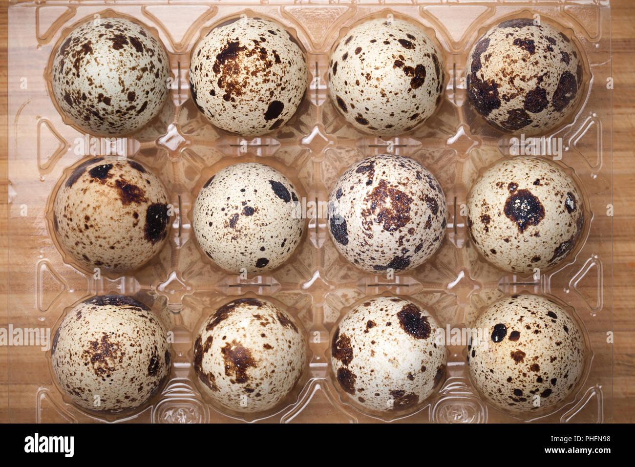 Quail Eggs in Plastic Container on Wood Background Stock Photo