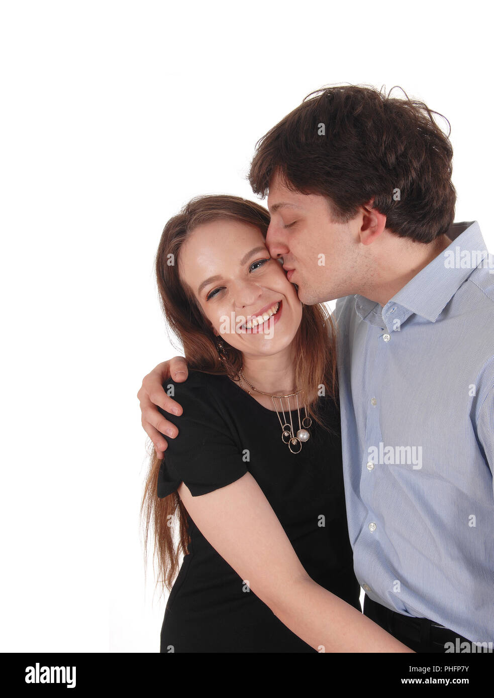 Close up portrait of a cute young caucasian blonde couple trying to kiss  where man is holding his girlfriend face in his hands close outside while  dating. Stock Photo