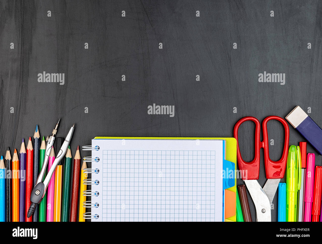 School suppiles on black board background. Stock Photo