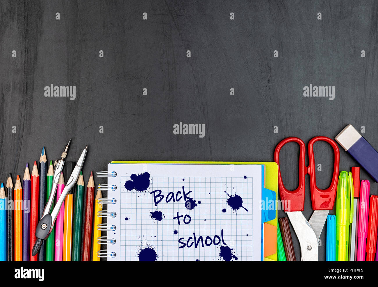 School suppiles on black board background. Stock Photo