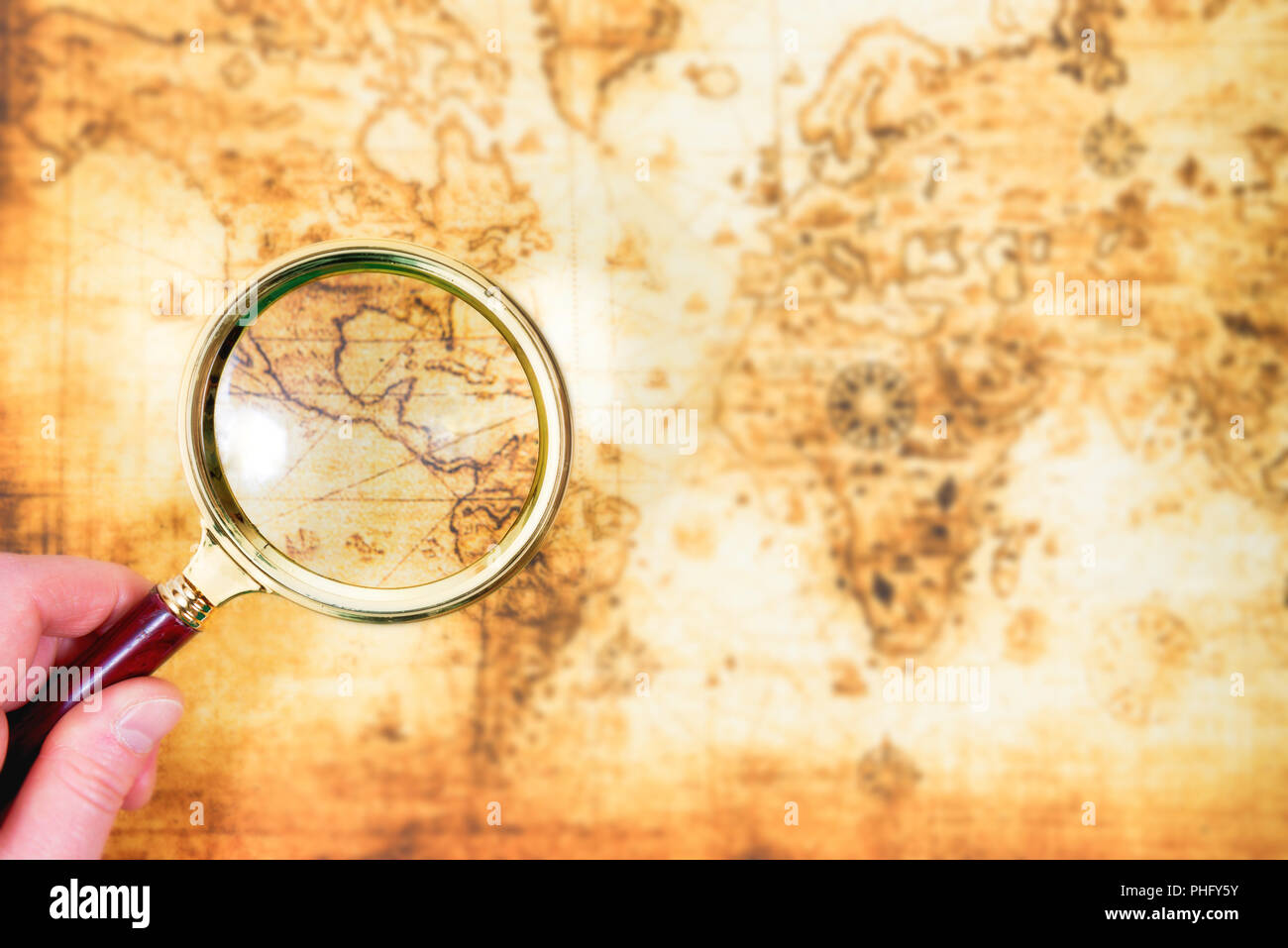 Old map and magnifying glass in a hand Stock Photo