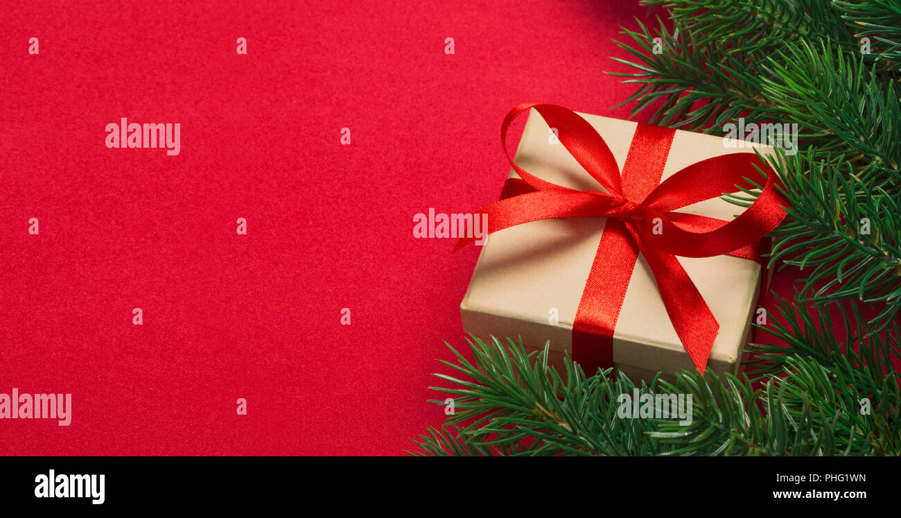 Branches of a Christmas tree and gift on a red background Stock Photo ...