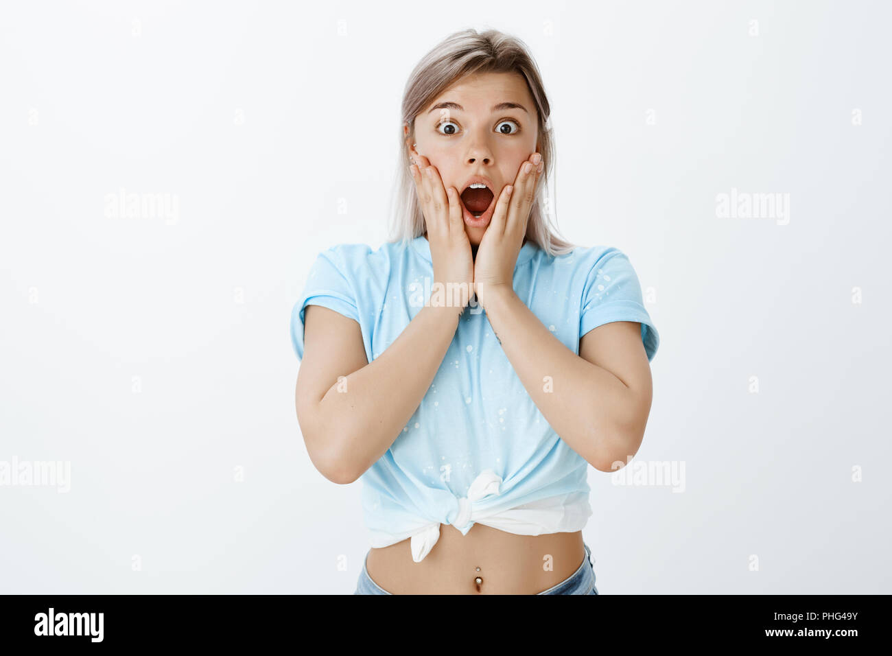 I think I am losing my mind, wow. Portrait of impressed and shocked good-looking sportswoman with pierced belly, gasping, dropping jaw while being wondered and stunned with something amazing Stock Photo