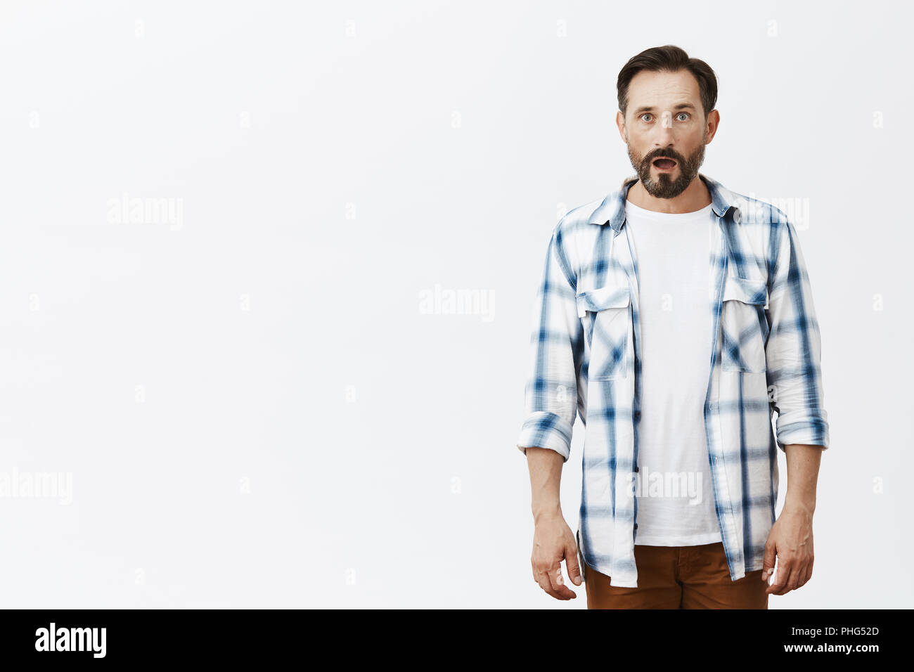 Guy losing speech, seeing amazing and unbelievable accident, witnessing ufo. Portrait of shocked speechless attractive mature caucasian man with beard and moustache, dropping jaw and staring at camera Stock Photo