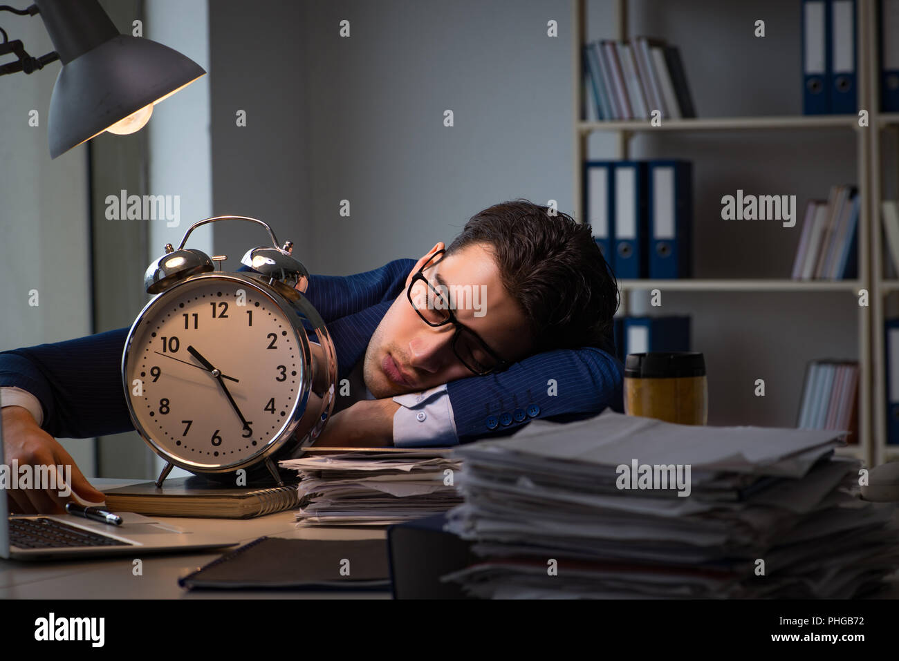 Businessman falling asleep during long hours in office Stock Photo