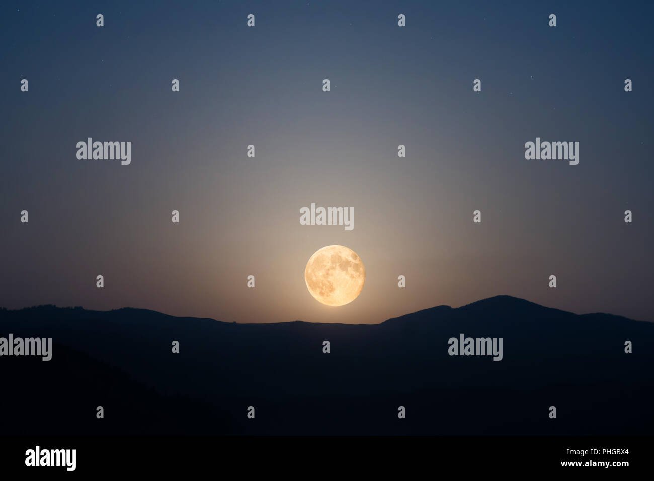 Big moon rising on night sky Stock Photo