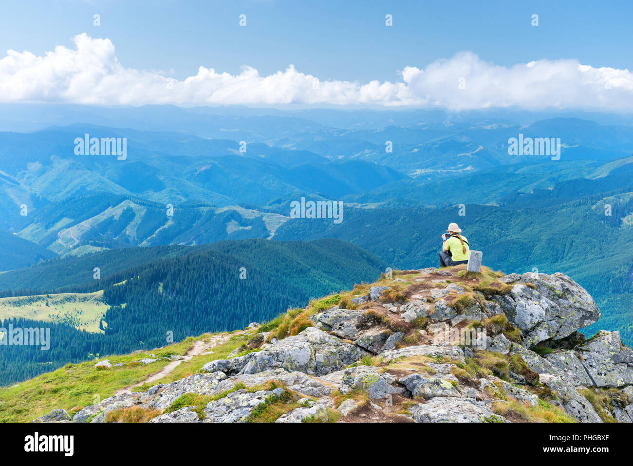 Young woman sitting on the cliff Stock Photo
