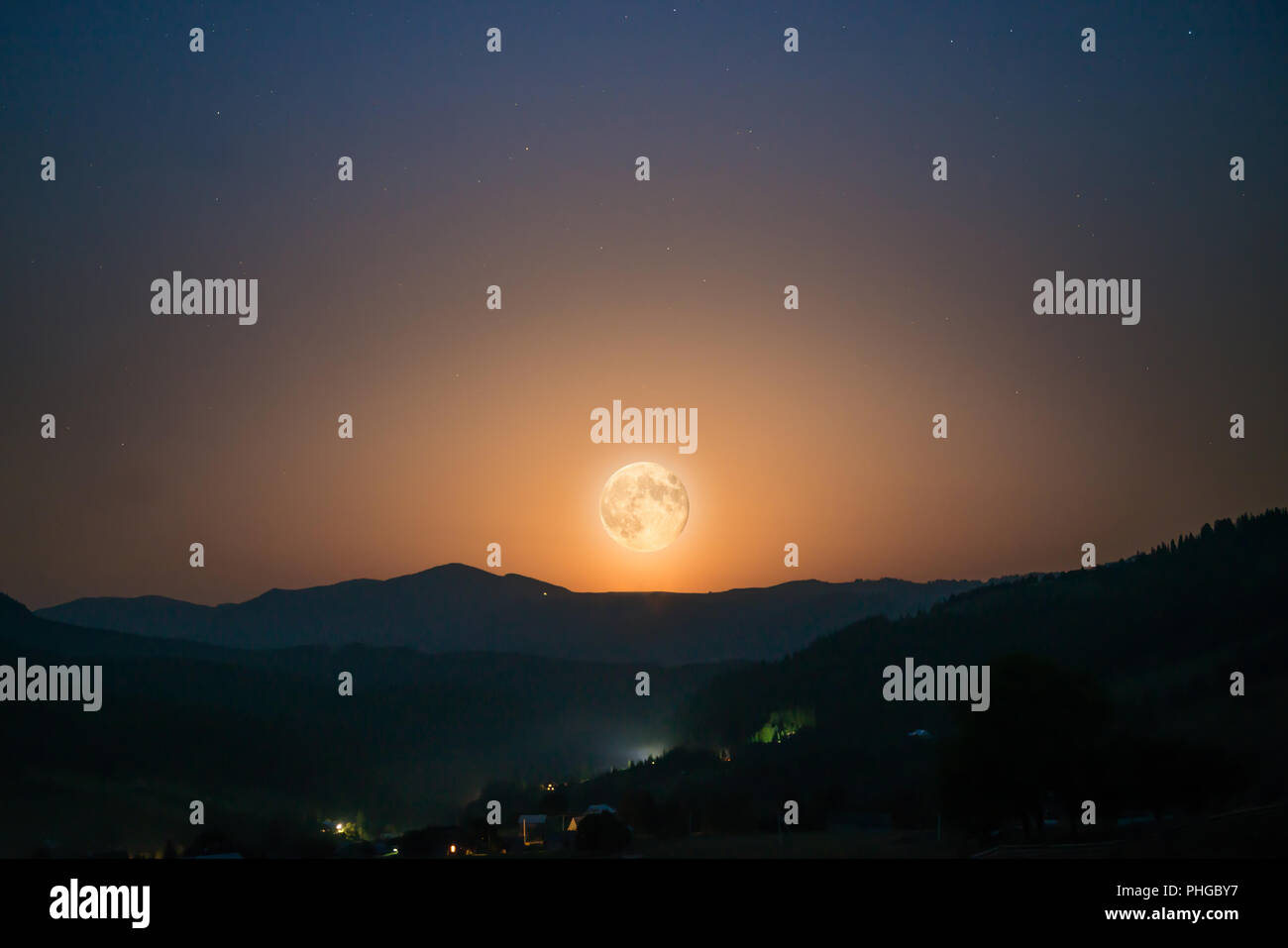 Big moon rising on night sky Stock Photo