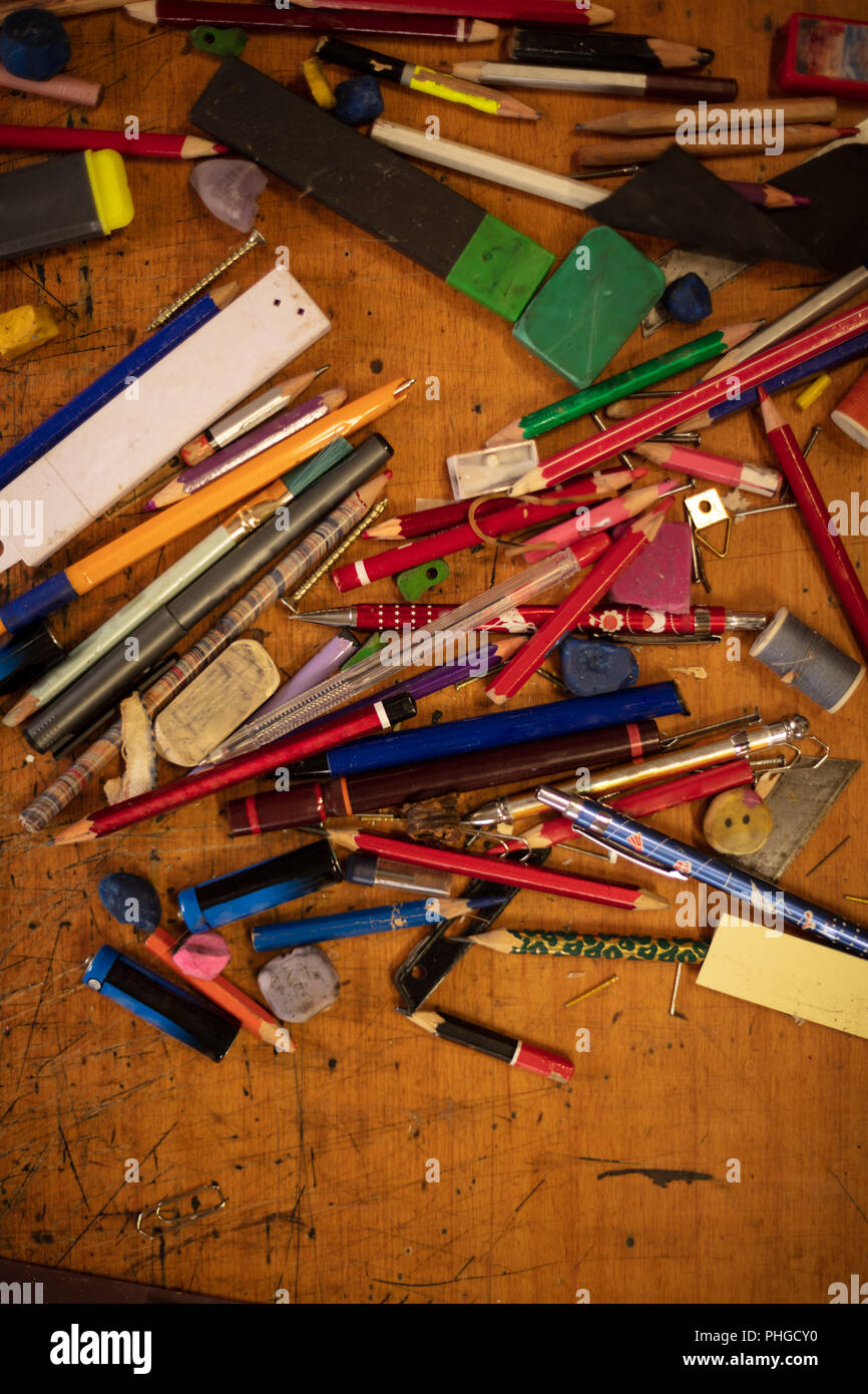 Assorted objects ; colored pencils, pens, crayons, erasers, binder