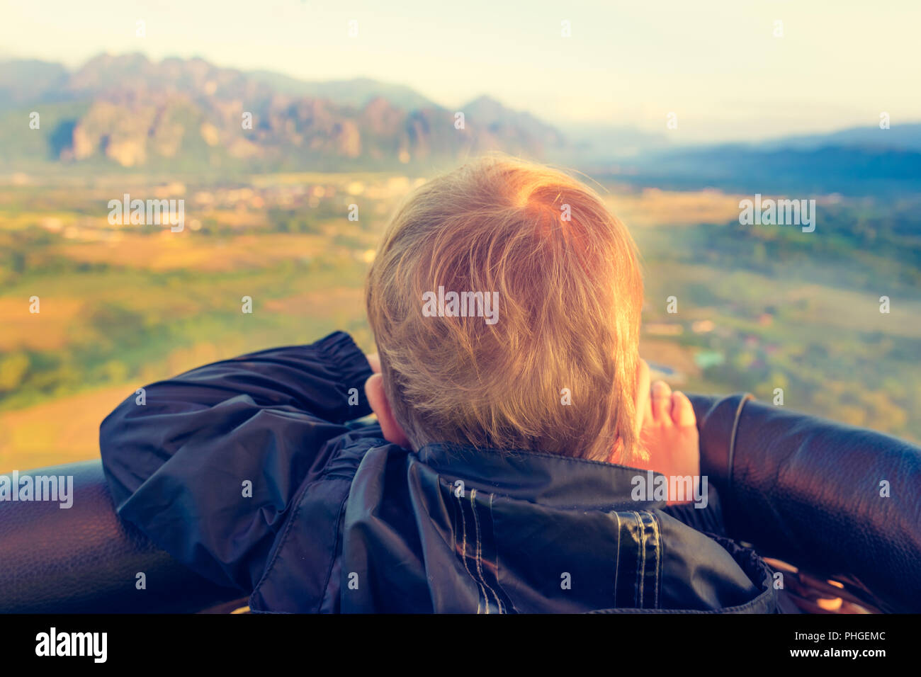 Boy looking from air balloon during flight. Laos. Stock Photo
