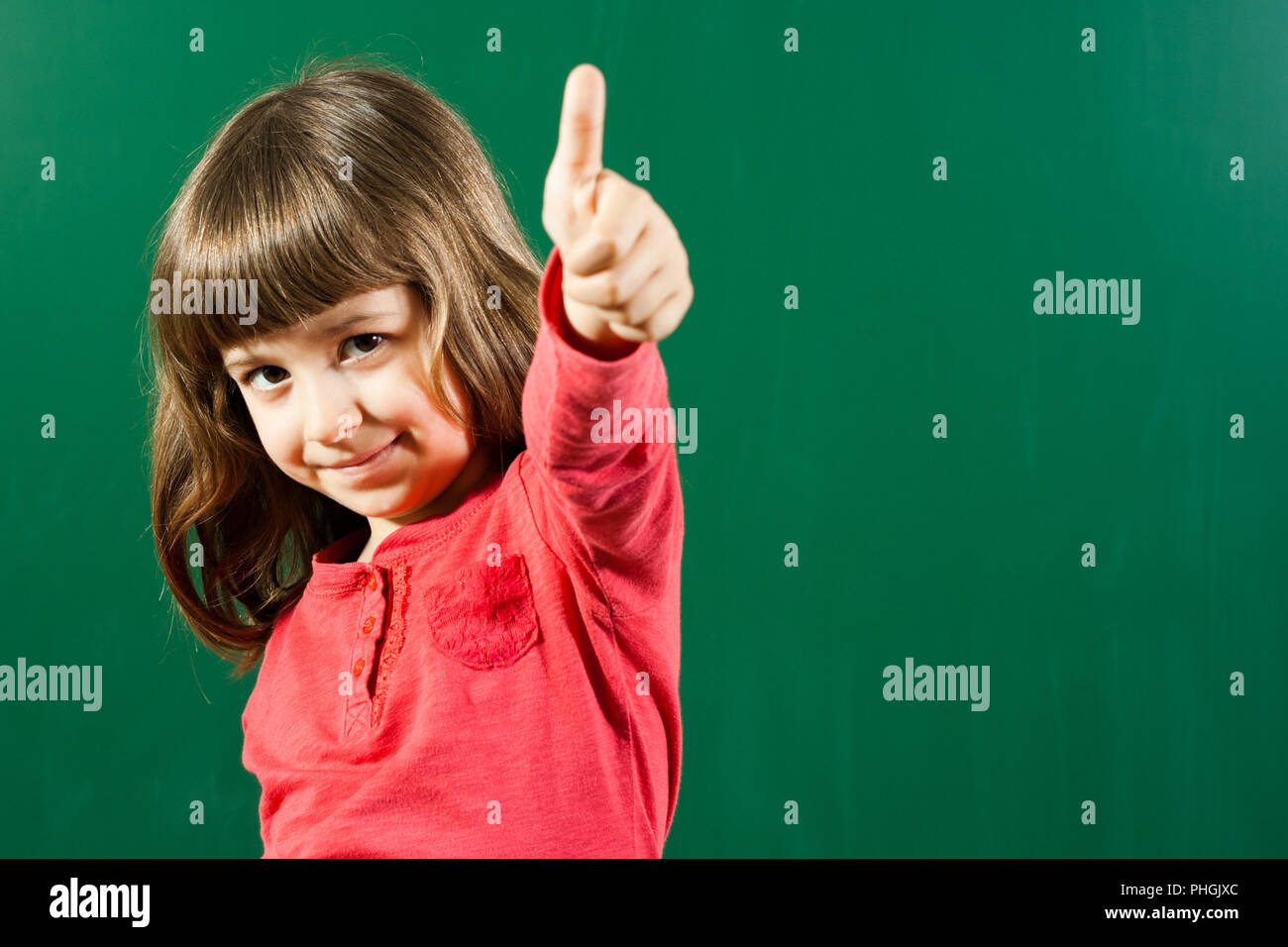 Cute schoolgirl with thumbs up Stock Photo - Alamy