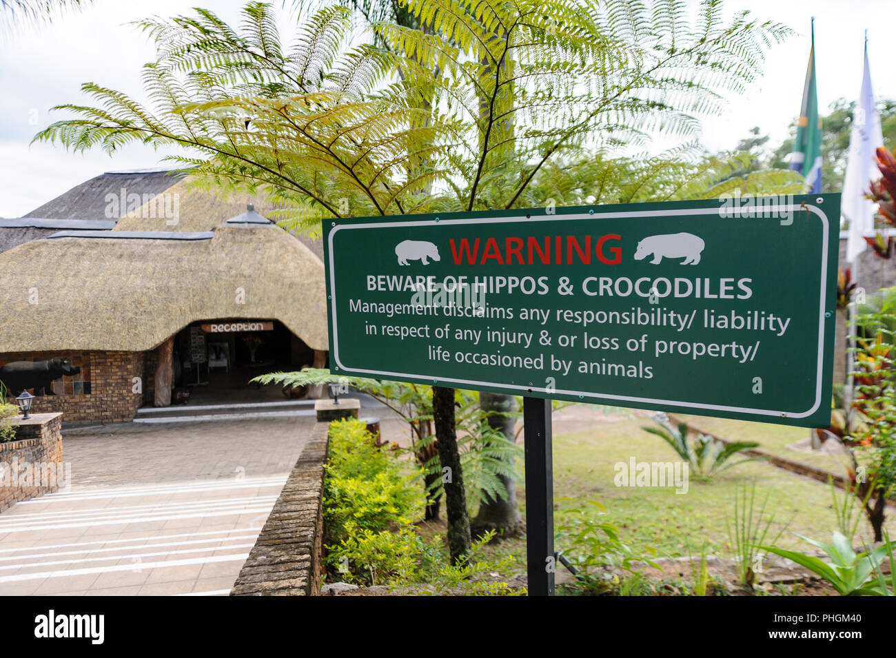 Warning sign board at the entrance of an hotel in South Africa showing the possibility to encounter dangerous animals like Hippos and Crocodiles Stock Photo