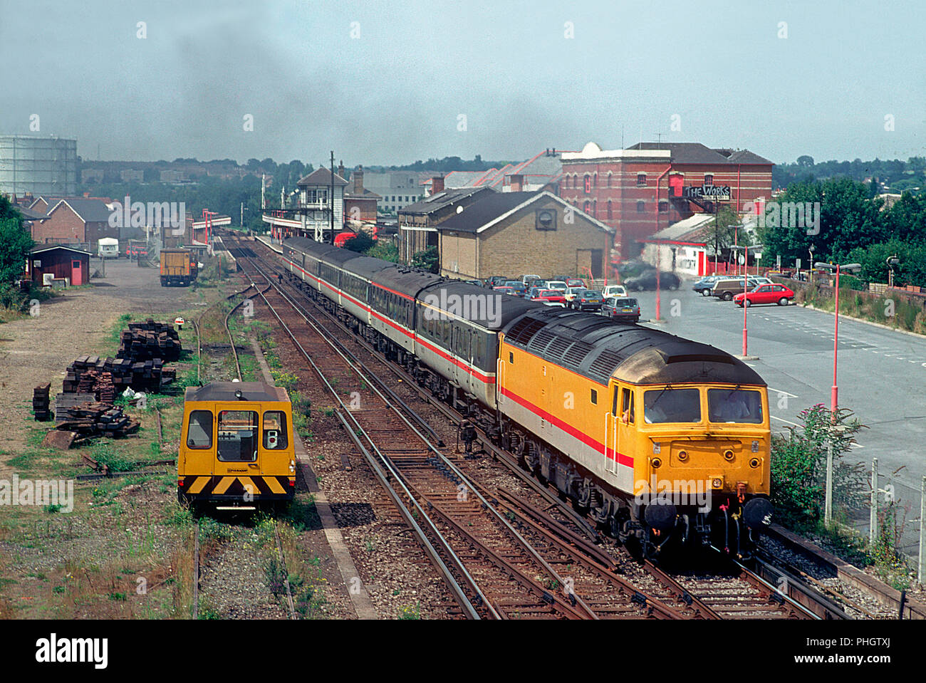 A class 47 diesel locomotive number 47803 in a unique yellow livery working an InterCity service heads away from Canterbury East on the 21st August 1993. Stock Photo