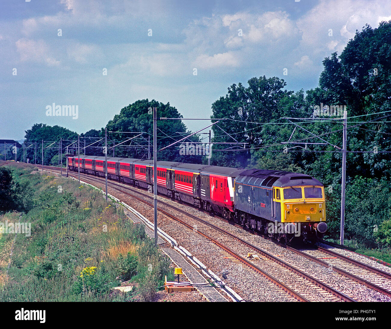 A class 47 diesel locomotive number 47840 ‘North Star” in a retro British Rail blue livery dragging a failed Virgin West Coast Trains service near Blisworth on the 9th July 2003. Stock Photo