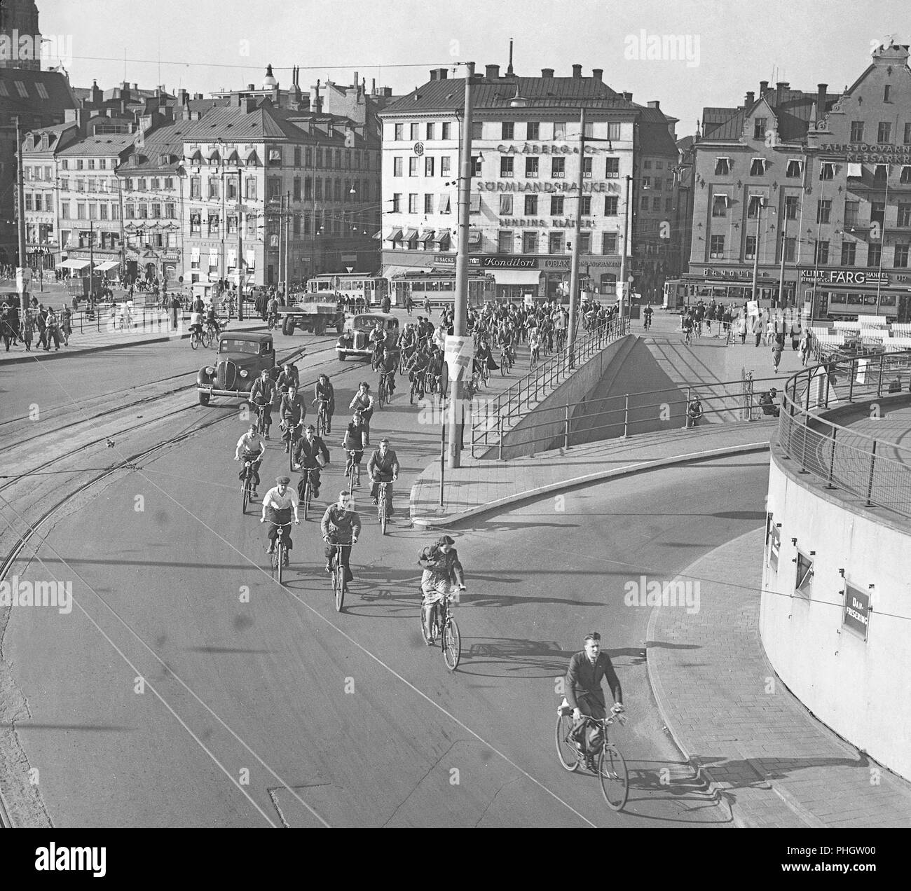 1940s cyclists. People on their bicycles are on their way through Slussen that was the traffic hub of central Stockholm, connecting the Old time with the south of Stockholm.  May 1940.  Photo Kristoffersson 129-13 Stock Photo