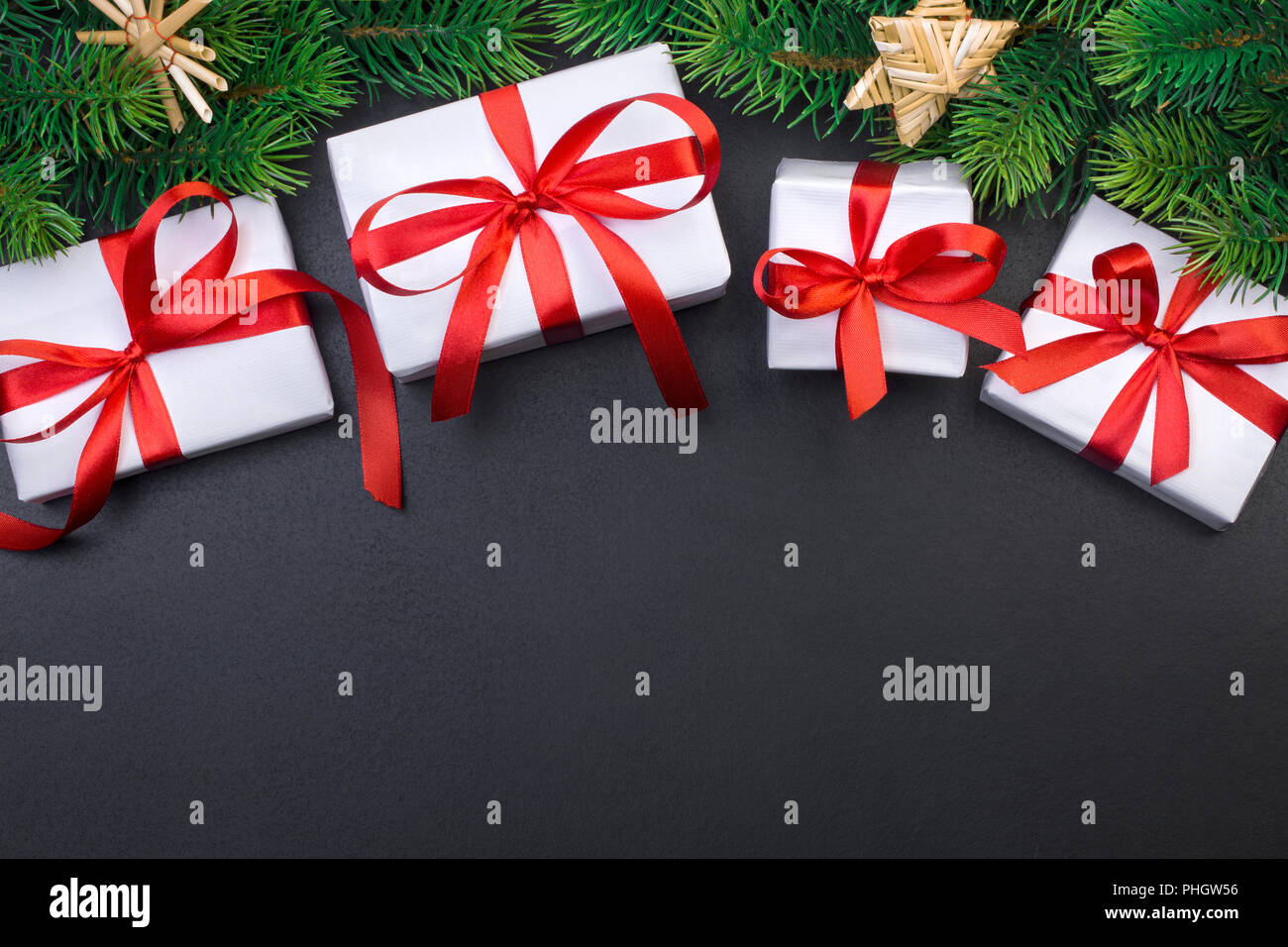 Christmas tree branch on a black background and gift box with a red ...