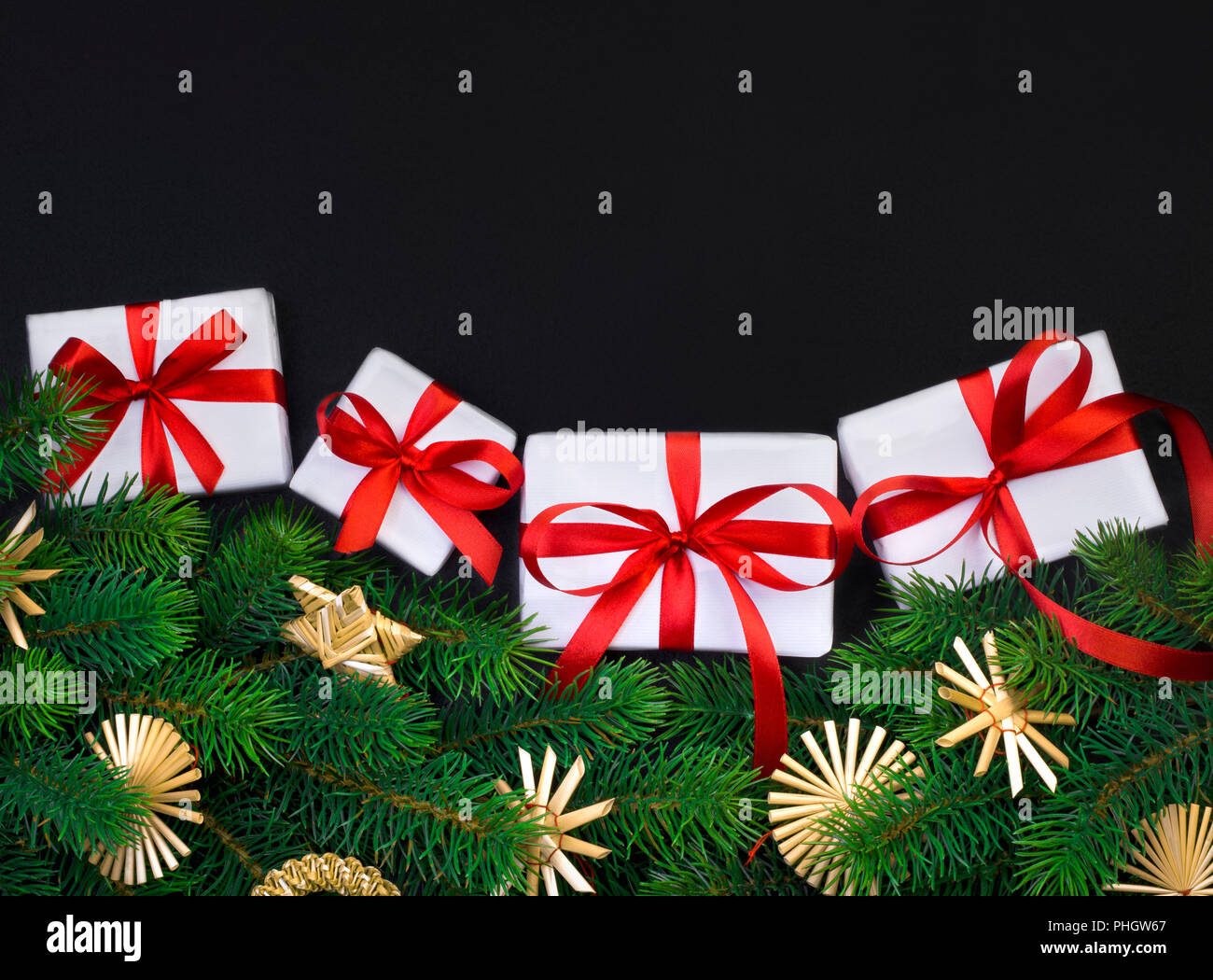 Christmas tree branch on a black background and gift box with a red ...