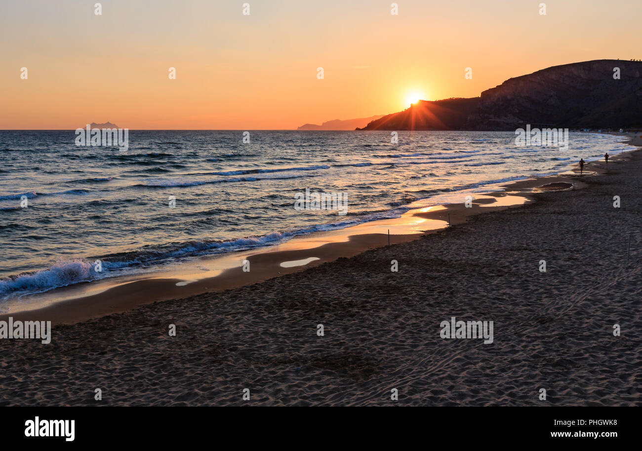 Sunset on sea beach Stock Photo - Alamy