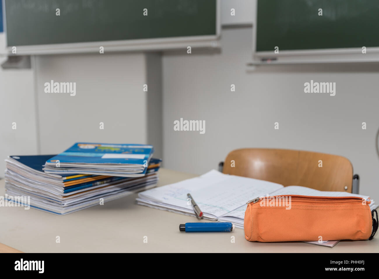 Pile of schoolwork at the teacher's desk in the classroom Stock Photo