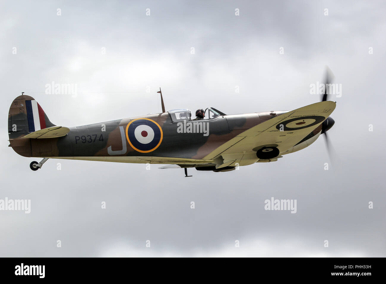 A Spitfire takes off from Duxford, with the landing gear having almost completed raising. Stock Photo