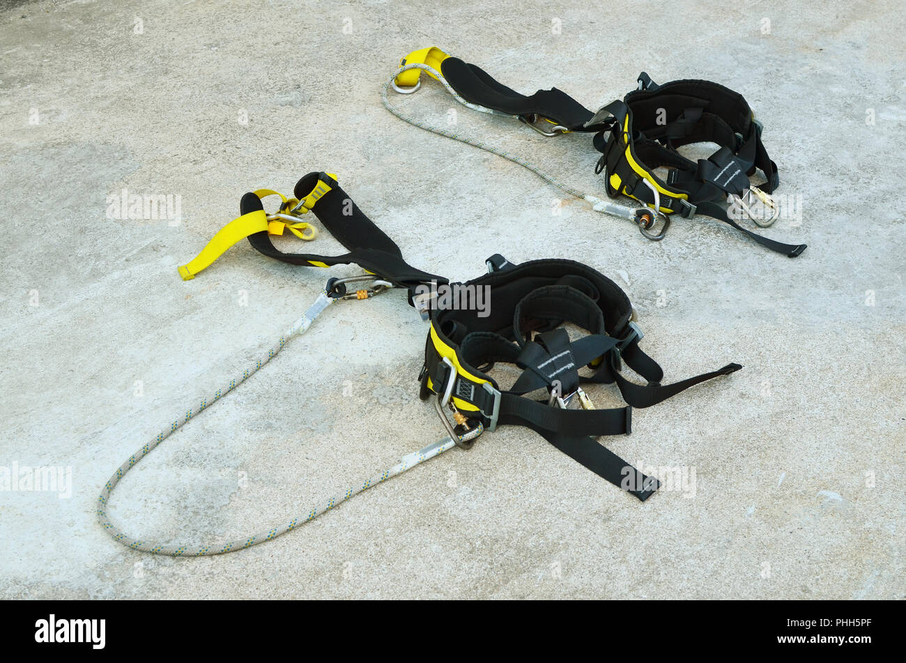 Kits of standard safety mountain climbing equipment lie on concrete