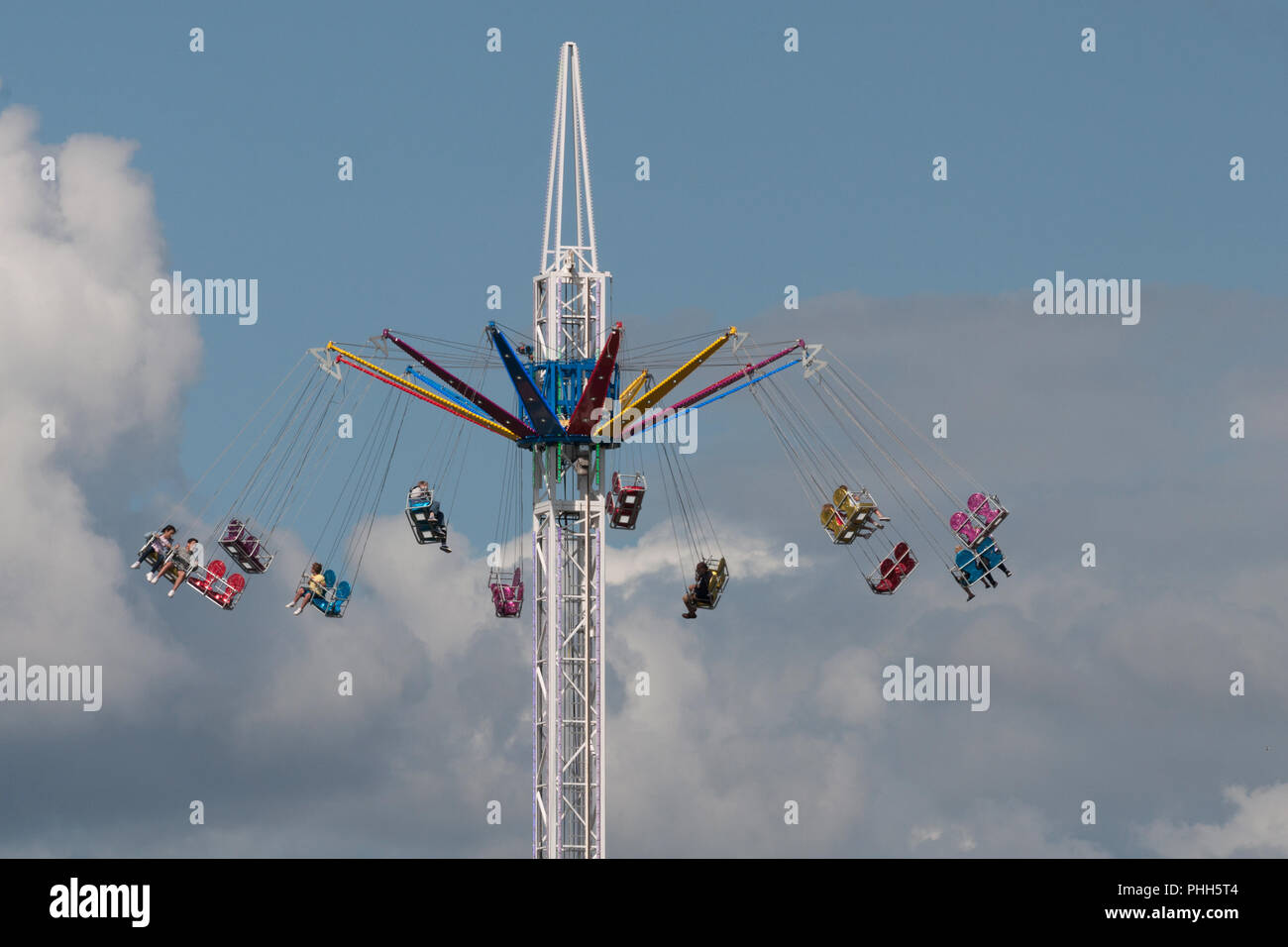Passengers On The Sky Tower At A Funfair Swing High Above