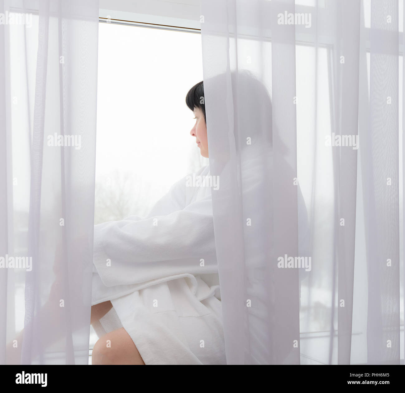middle-aged woman by the window Stock Photo