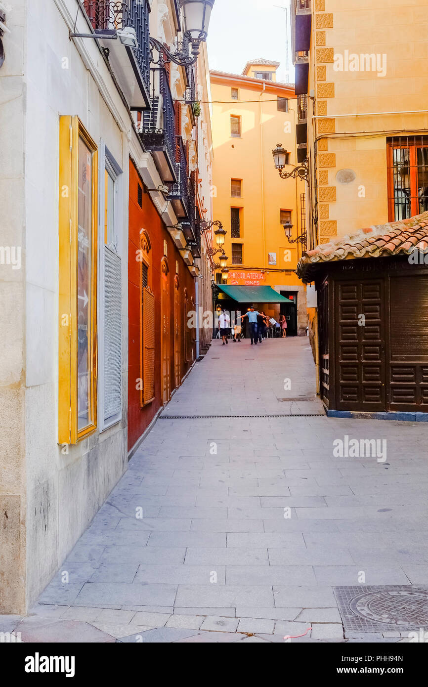 A view of View of Chocolateria San Gines from Calle Arenal during the day with dark shades and bright sunlight hitting the back door of the parish Chu Stock Photo