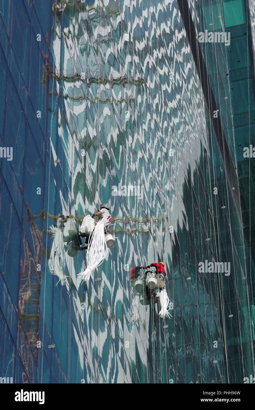 Windows washers cleaning glass facade of a high rise building Stock ...